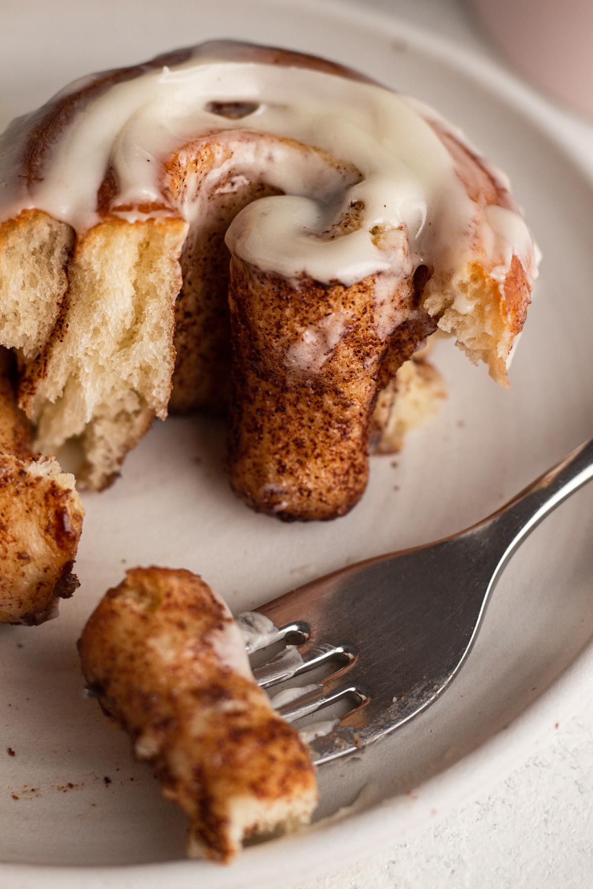 A warm cinnamon roll, pulled apart