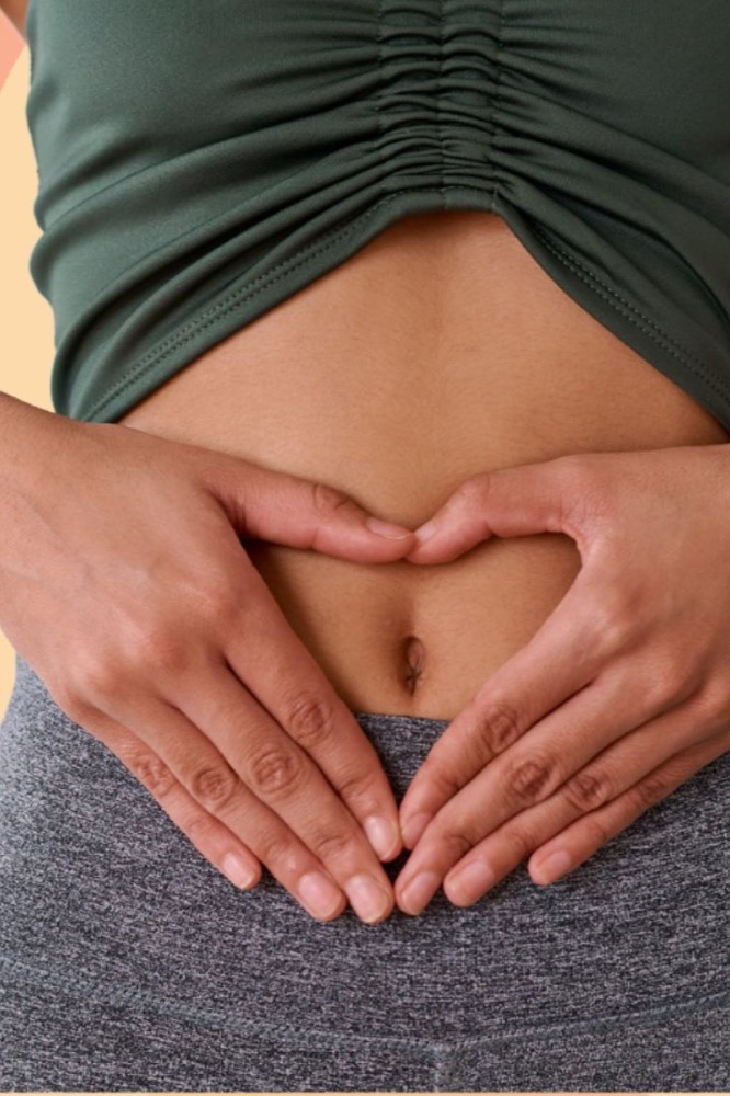 Hands forming a heart over a happy, settled stomach