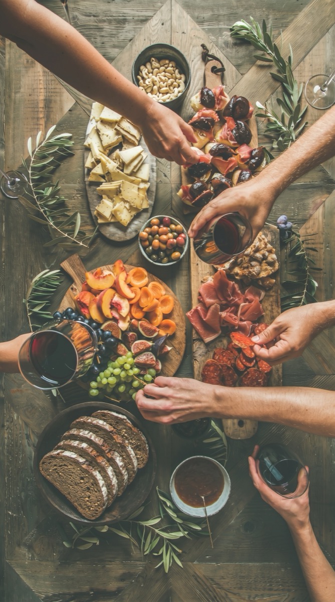 An overhead table spread shared by many hands