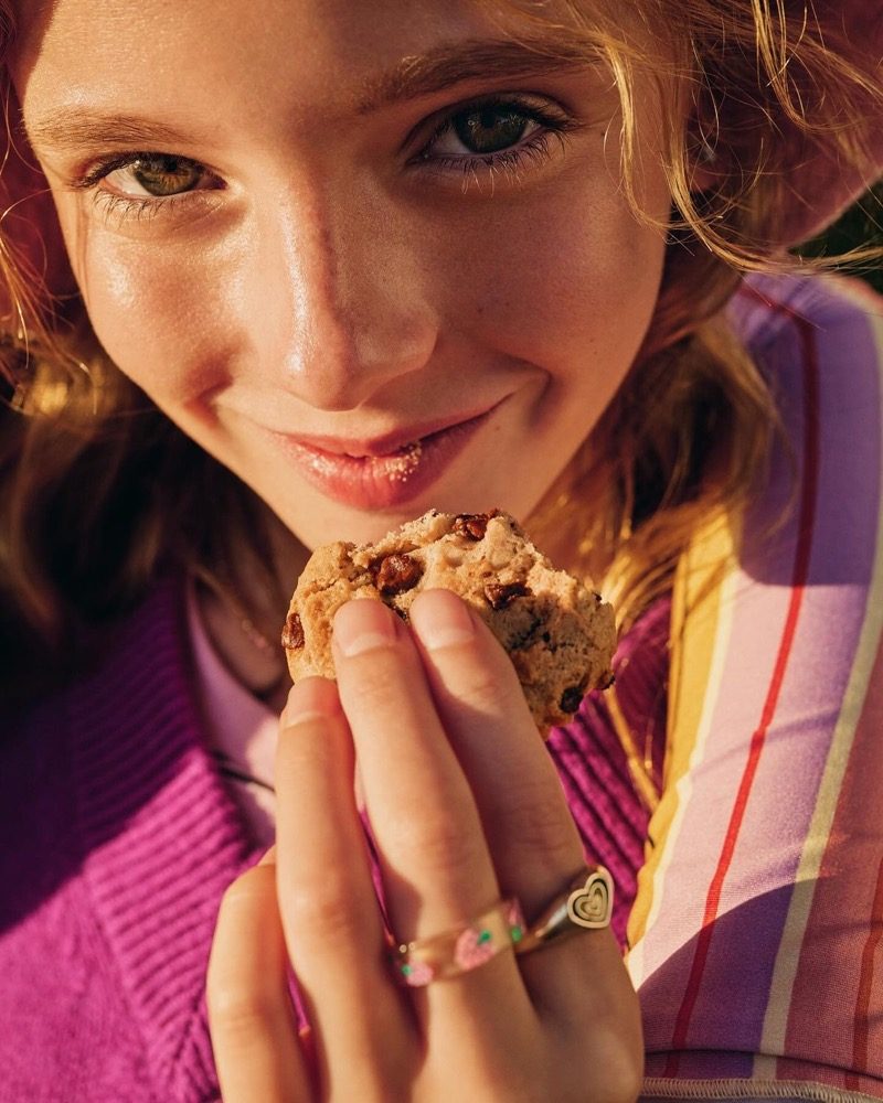 A girl eating something sweet in warm light