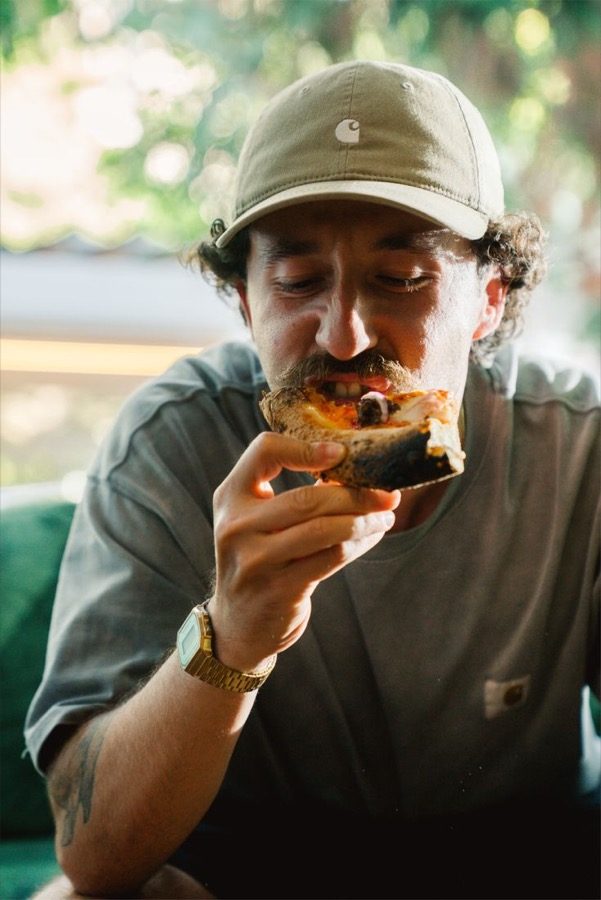 A man taking a bite of a pastry