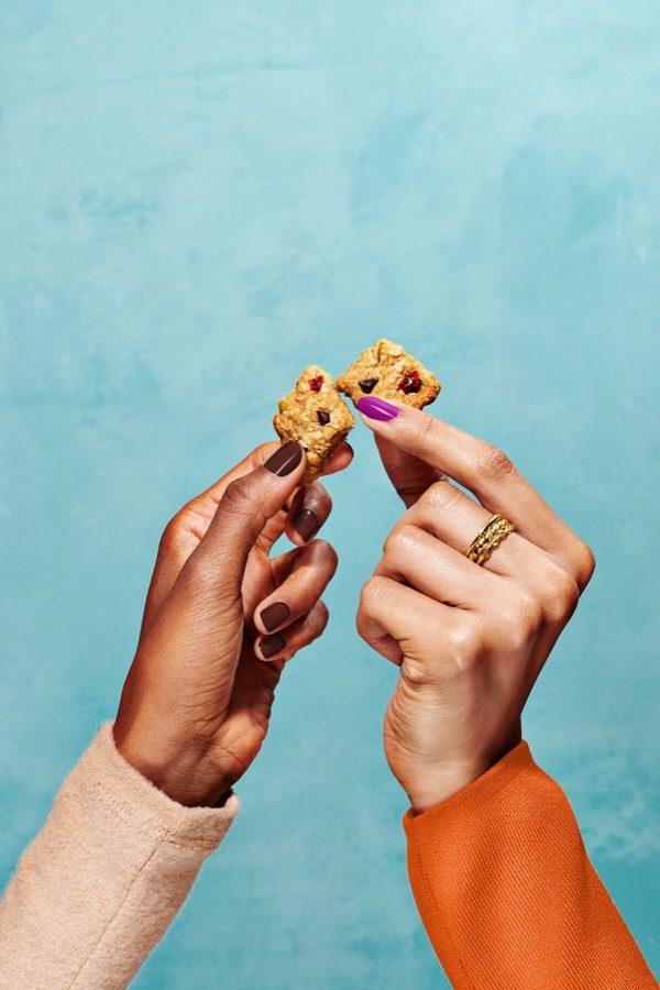 Two hands breaking one treat in half